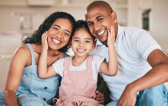 Family in portrait, parents and child are happy and relax at home, love and bonding together on sofa. Happiness, people in living room with relationship and spending quality time at the weekend